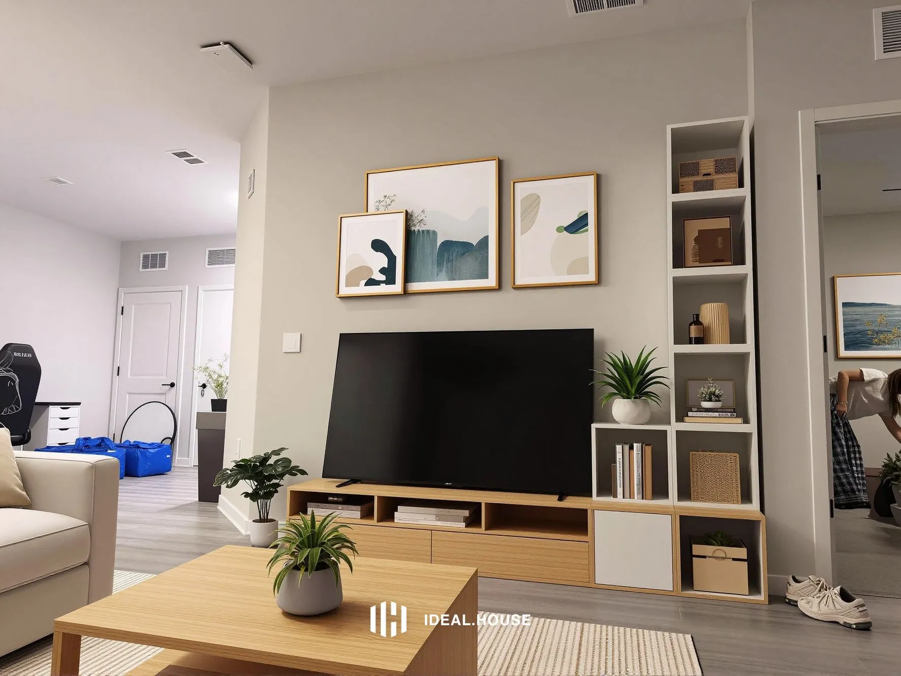 Decorated with green plants, lighting fixtures, a rug, a TV, and paintings