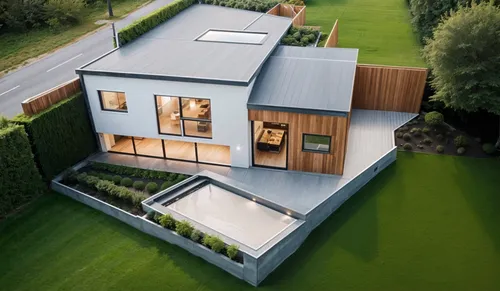 a modern house sits in the middle of the grassy area,modern house,cubic house,cube house,folding roof,modern architecture,metal roof,weatherboarding,house shape,weatherboards,dunes house,weatherboard,