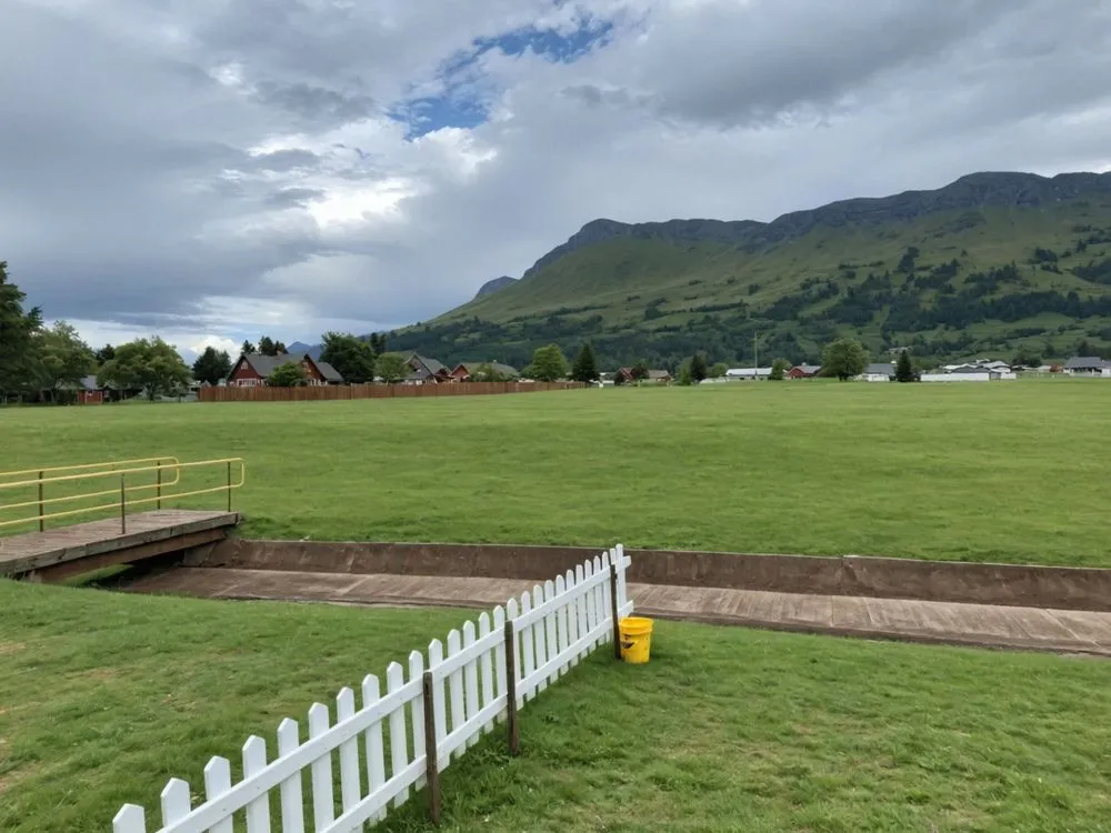 a view from inside the fence of a large open field