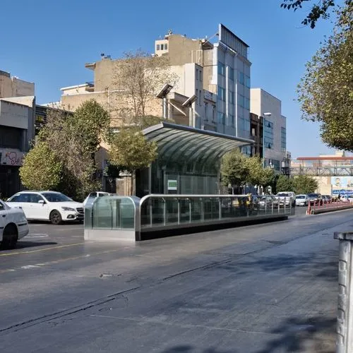 Design a modern station for a contemporary city using glass and grey composite materials. Include seating areas and advertising spaces. The roof should be curved.,a street scene with cars driving down