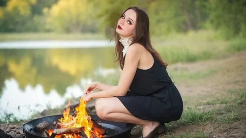 ДЕВУШКА. 
 в прерии у реки готовит обед на костре яичницу,a girl sits near the fire with her eyes open,fire background,pyromaniac,flammability,fire starter,aflame,wood fire,fire angel,burning hair,fir