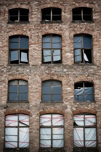 Front photo about Many broken windows on old abandoned warehouse.,a wall with many windows is shown with broken curtains,old windows,row of windows,broken windows,windows,window frames,fenestration,wi