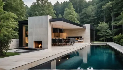 An ethereal photograph, A detailed, serene oil painting. Pool house exterior.  Dark black wood and white travertine stone. Long Fireplace on the far big wall. Forest behind.,the inside of a home with 