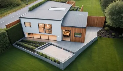 Una casa moderna de dos pisos con un diseño arquitectónico elegante y contemporáneo. La estructura cuenta con paredes de tonos blancos y grises, amplias ventanas de vidrio que permiten una iluminación