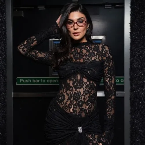 a woman wearing glasses poses in front of an elevator,black and lace,see through,photo session in bodysuit,see thru,mesh and frame,catsuit,librarian,elevator,tats,bodysuit,lace,lira,arias,marina,puma,
