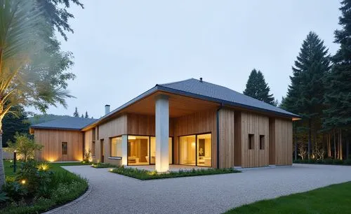 a home with a driveway surrounded by trees,timber house,wooden house,modern house,forest house,residential house,house in the forest,holiday villa,wooden roof,chalet,house shape,villa,danish house,mod