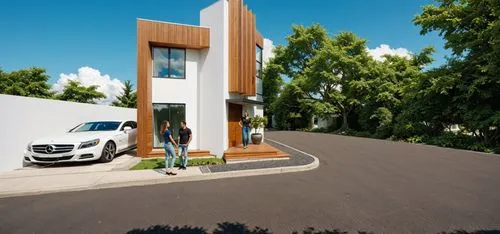 PHOTOGRAPH TAKEN WITH A KODAK CAMERA, WITH A 35MM LENS of a modern two-story house with a contemporary design. the house has a white exterior with wooden accents, and a large glass window on the secon