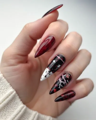 Nils Design, hallowen nails,
woman’s hand, Long manicure nails with a pointed shape and a gothic and dark nailart, white background, reference, horror, halloween, red black white,a womans hands holdin