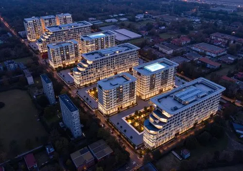 The apartment complex has 16 floors. It is made of concrete, glass, and metal. The lower three floors have a more massive and colorful design, while the top three floors have a texture that stands out