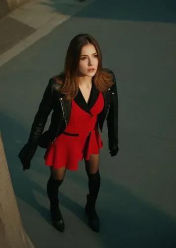A striking full-body conceptual art of a beautiful 23-year-old Caucasian woman, with long brown hair cascading to her shoulders, dressed in a black dress with a neckline and a bold red leather jacket,