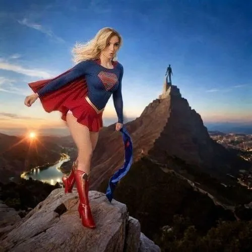 a beautiful blond woman wearing a red skirt and a blue shirt on top of a mountain,superwoman,super woman,super heroine,superwomen,wonder woman city,wonder woman
