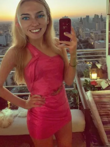a blonde woman in pink dress taking picture with cell phone,blond girl,petite,giantess,payola,short dress,miniskirt