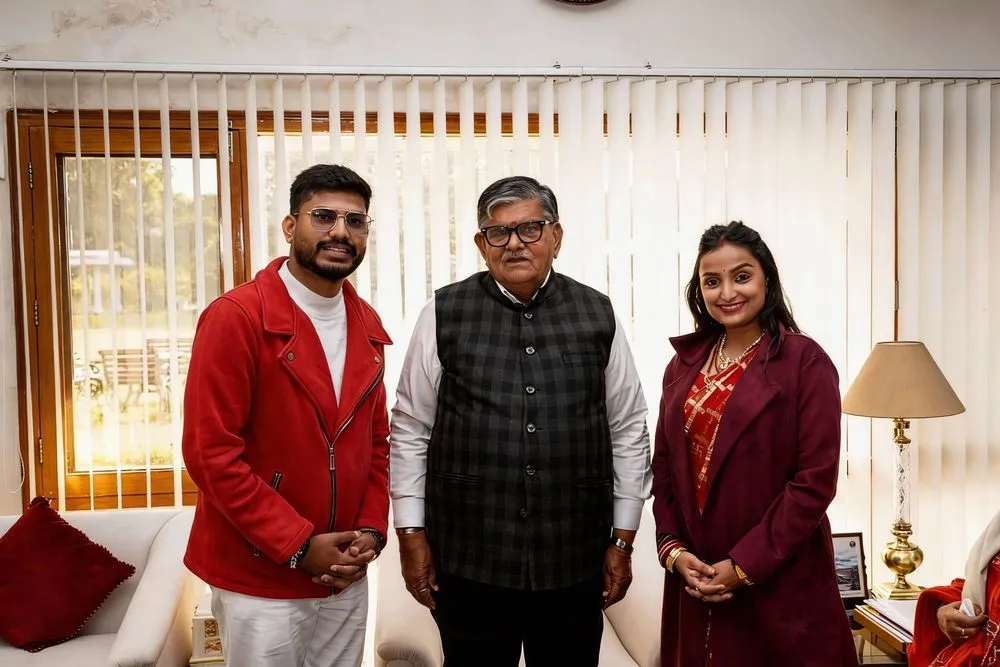 three men and a woman standing together in a living room