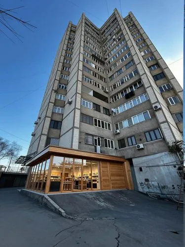On the ground floor, instead of traditional blue iron outbuildings, there is a modern store characterized by glass windows and wooden elements.,this building is called the grand tower,headquarter,new 
