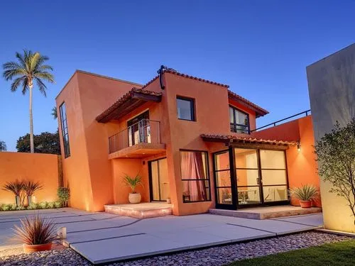 PHOTOGRAPH TAKEN WITH A KODAK CAMERA, WITH A 35MM LENS A contemporary, two-story, Mexican-style house at dusk, with dim ambient lighting and a starry sky amidst a tropical landscape. It is predominant