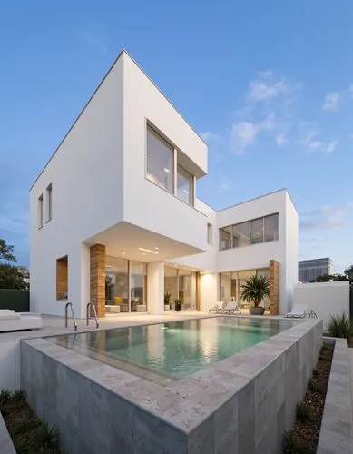 A modern, minimalist white house with a rectangular swimming pool in the middle of the image. the house is a two-story, modern building with a minimalist design, featuring a white exterior with large 