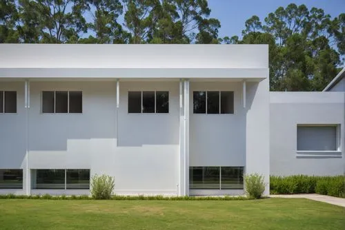 1building,white contemporary architectural home sits on the edge of a well manicured yard,cube house,modern house,cubic house,modern architecture,residential house,frame house