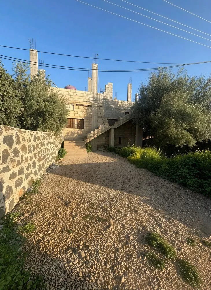 the road is winding and the building in the background is made out of stone