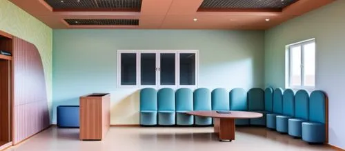 international kids school reception area n waitng area ,a large room with blue chairs and a round table,treatment room,therapy room,examination room,doctor's room,addiction treatment,deinstitutionaliz