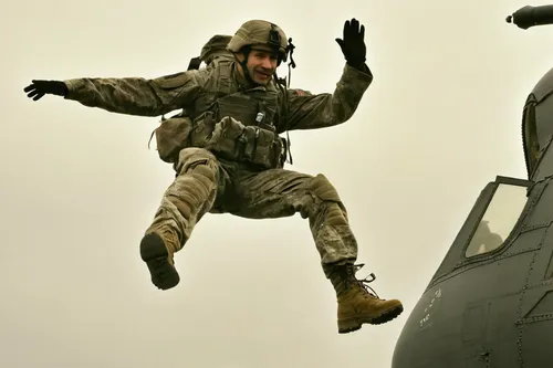 <strong>February 24:</strong> A U.S. soldier salutes while jumping out of an aircraft in Germany.,paratrooper,airman,parachute jumper,parachutist,tandem jump,leaping,air combat,parachuting,jumping,cal