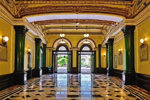 Neoclassical Manila Post Office, grandiose, historical building, ornate details, columns, arches, domed roof, intricately carved stonework, intricate moldings, grand staircase, polished marble floors,