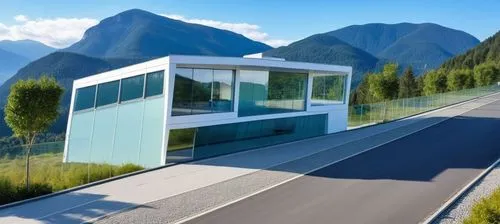 Diseño de un un Edificio Moderno, techos planos y rectos, grades ventanales de vidrios transparentes reflexivos en la fahada, el edificio en de dos pisos en elprmer piso un acceso rectagular amplio, u