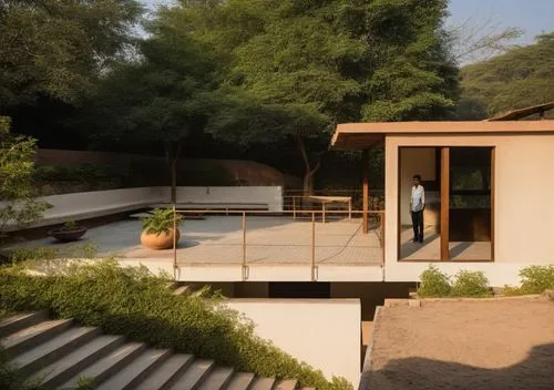 a person walking towards a small, modern building,mid century house,dunes house,neutra,auroville,pool house,amanresorts