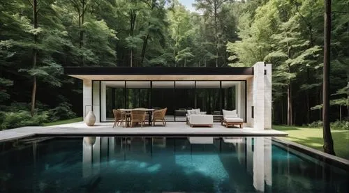 An ethereal photograph, A detailed, serene oil painting. Pool house exterior.  Dark black wood and white travertine stone. Forest behind.,a patio with two lounge chairs next to a pool surrounded by tr