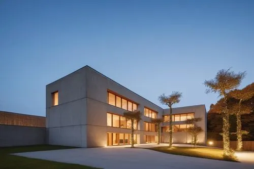 an outside building lit up at night,modern architecture,architektur,eisenman,modern house,siza,moneo