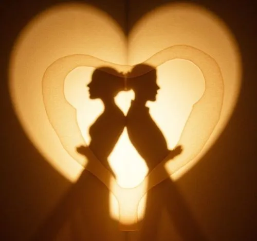 a sculpture representing a man and a woman leaning back to back to form a heart shape,a silhouette of two people holding hands in front of a heart shaped light,vintage couple silhouette,couple silhoue