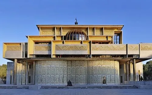 a yellow building with an arched doorway and two men standing outside,iranian architecture,azmar mosque in sulaimaniyah,persian architecture,ctesiphon,hala sultan tekke,samarqand,mahdavi,mohtashemi,kh