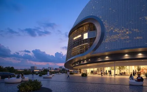 A photo-realistic rendering of a modern building with a curved, perforated facade at dusk. the building is situated in the middle of the image, with a city skyline visible in the background. the sky i