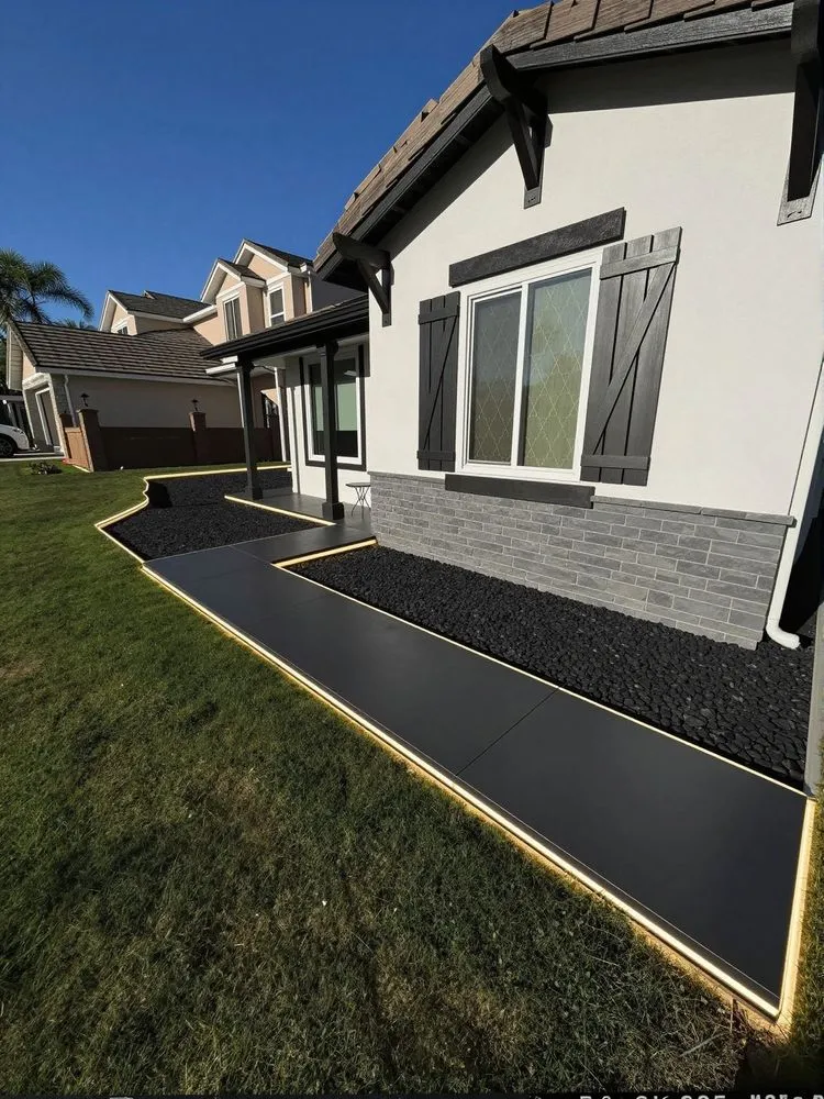a white house with black trim and landscaping