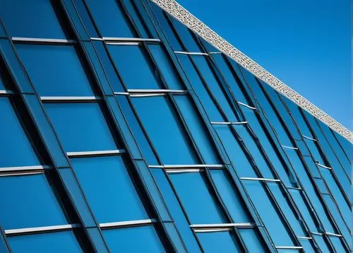 Modern building, futuristic architecture, sleek lines, metallic materials, glass façade, geometric shapes, urban cityscape, daytime, clear blue sky, low-angle shot, symmetrical composition, shallow de