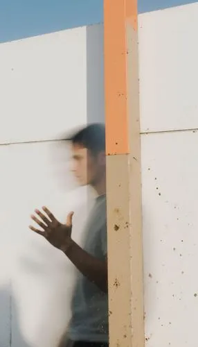 a man standing next to a wall near two hands,pinhole,window washer,climbing wall,two meters,pinholes,counting frame