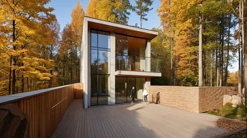 two people standing on a deck near a house,forest house,timber house,house in the forest,cubic house,dunes house,wooden house,inverted cottage,modern house,summer house,modern architecture,danish hous