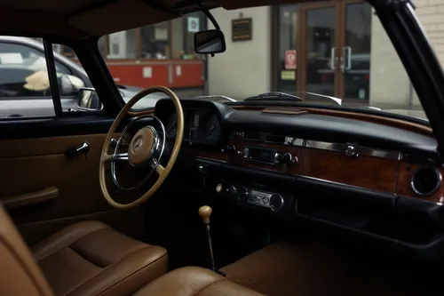 a dashboard and seats of a small car,car interior,the vehicle interior,the interior of the,driver's cab,interiors,wood grain,interior,empty interior,dashboard,classic car,leather steering wheel,cockpi