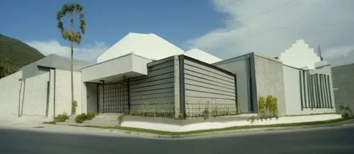 Diseño de una casa estilo mínimalista, ubicada en una esquina, con volúmenes qué se intersectan, con una reja reticular de acero, como portón para el acceso a cochera, ventilas largas para recamaras, 