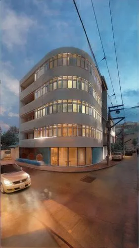 rental suites. The building features a clean white facade with rounded corners. The ground-floor lobby, furnished with sofas, serves as a communal space for residents to host guests, complemented by g