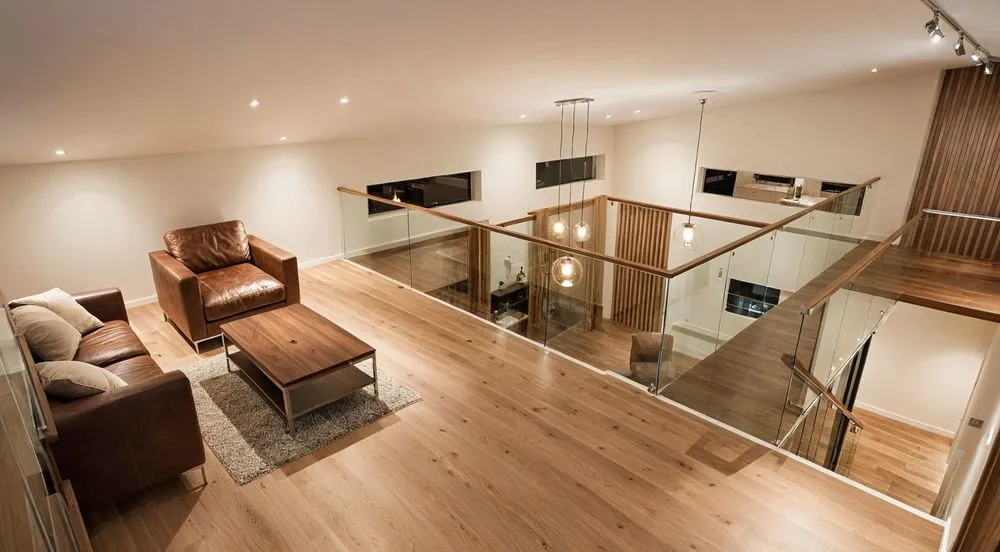 living room area with wooden flooring, chairs and stairs