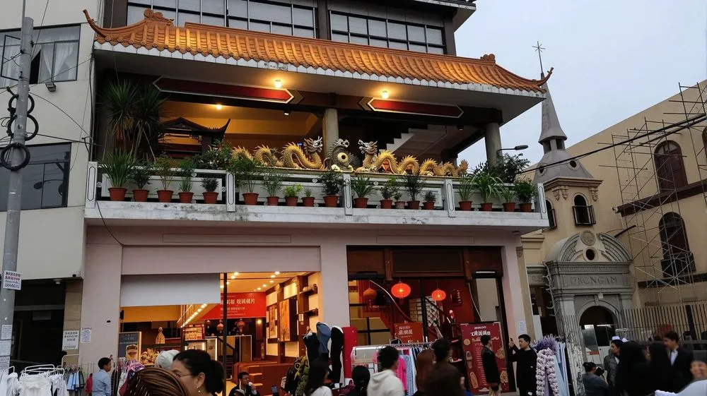 people walk in the street near an asian restaurant