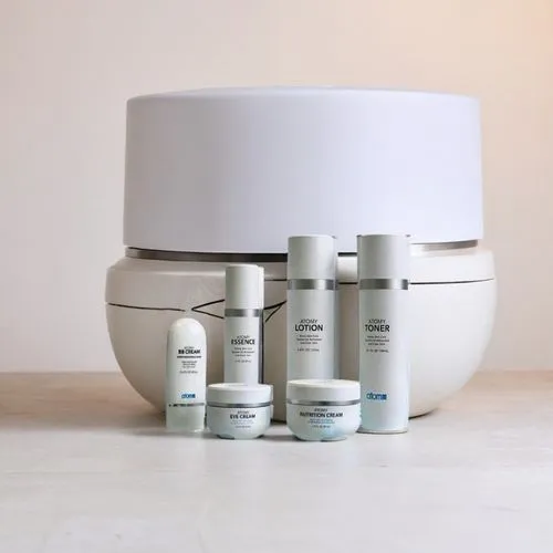 Design a soft and luxurious background for Atomy cream with a focus on elegance and simplicity. The backdrop should be in calming shades of ivory, pale peach, and light gold. Use a smooth, almost ethe