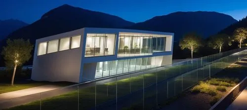 Diseño de un un Edificio Moderno, techos planos y rectos, grades ventanales de vidrios transparentes reflexivos en la fahada, el edificio en de dos pisos en elprmer piso un acceso rectagular amplio, u