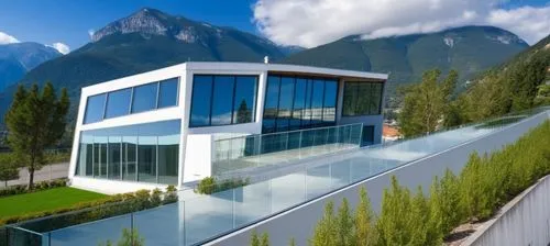 Diseño de un un Edificio Moderno, techos planos y rectos, grades ventanales de vidrios transparentes reflexivos en la fahada, el edificio en de dos pisos en elprmer piso un acceso rectagular amplio, u