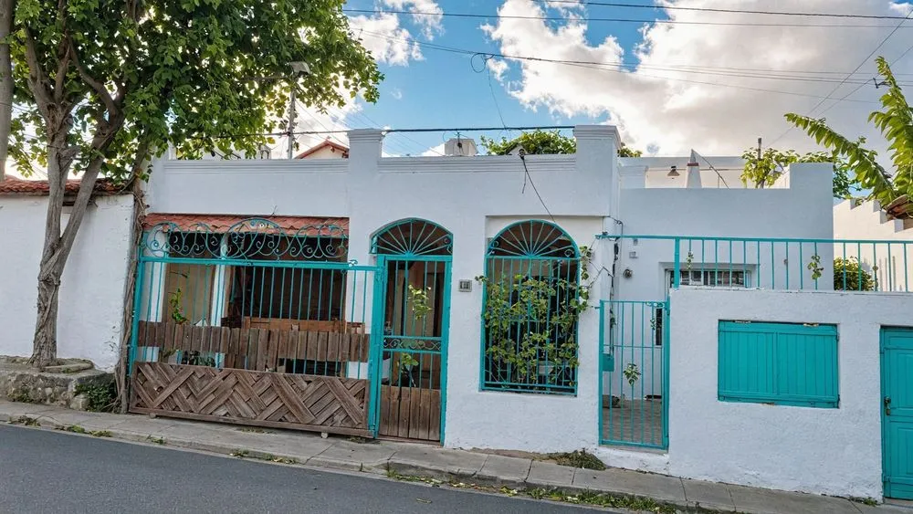 a white building with blue windows and blue shutters