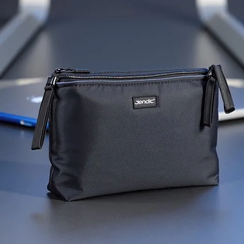 A futuristic zipper pouch made of dark gray, water-resistant nylon with a diamond-textured pattern, standing upright on a reflective metallic surface. The zipper is a matte black with a slim pull tab,