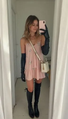 "A shaky, unplanned mirror selfie video taken with a smartphone, capturing a girl casually getting ready for a summer day out with friends. The room is brightly lit with cool white lights, giving the 