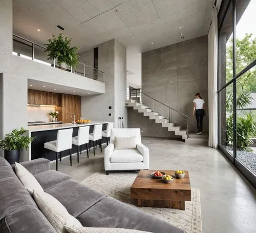A modern, minimalist living room with a contemporary design. the room features a large, open-concept kitchen with a white countertop, dark cabinets, and a large window on the right side, allowing natu