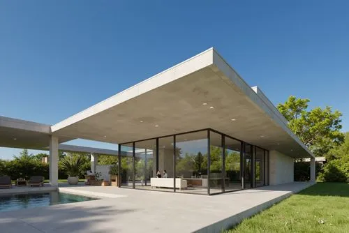 A modern, minimalist house with a minimalist design, featuring a large, rectangular concrete structure with a sloping roof and large glass walls that allow natural light to filter through. the house i