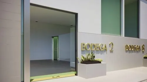 “Vista detallada de la entrada de la ‘Bodega 2’ en un complejo industrial moderno. La entrada cuenta con una puerta doble de cristal con tiradores metálicos minimalistas, que permite visibilidad hacia